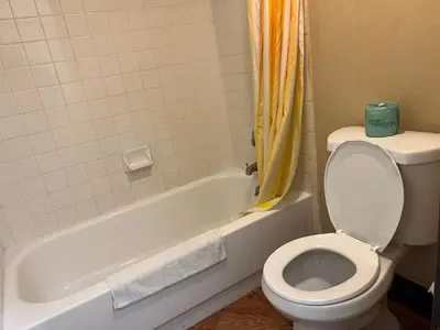 a bathroom with a toilet and a bath tub with a toilet paper at Lebanon Inn Motel in Lebanon