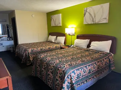 two beds in a hotel room with green walls at Lebanon Inn Motel in Lebanon