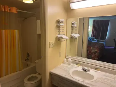 a bathroom with a sink and a toilet and a mirror at Lebanon Inn Motel in Lebanon