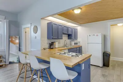 a kitchen with blue cabinets and white appliances at Cozy Boho-Chic Loft about 2 Mi to Downtown Cincinnati in Cincinnati