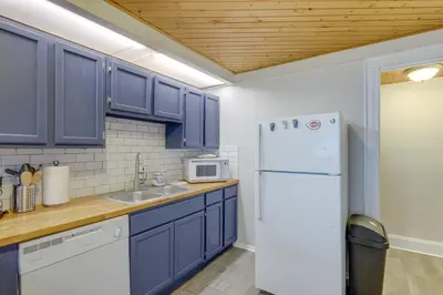 a kitchen with blue cabinets and a white refrigerator at Cozy Boho-Chic Loft about 2 Mi to Downtown Cincinnati in Cincinnati
