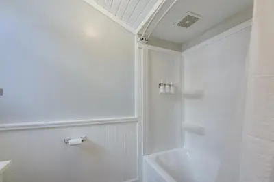 a white bathroom with a shower and a sink at Cozy Boho-Chic Loft about 2 Mi to Downtown Cincinnati in Cincinnati