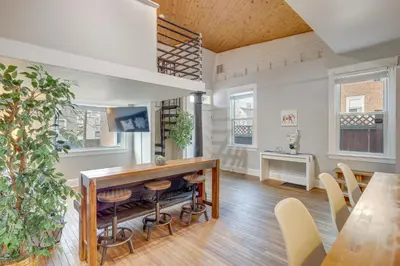 a living room with a bar and a table and chairs at Cozy Boho-Chic Loft about 2 Mi to Downtown Cincinnati in Cincinnati