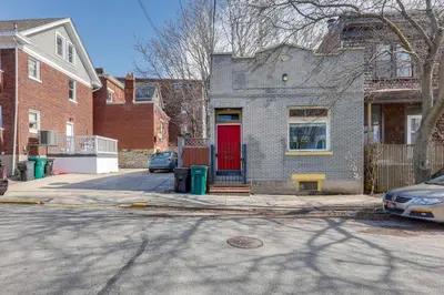 a house with a red door on a street at Cozy Boho-Chic Loft about 2 Mi to Downtown Cincinnati in Cincinnati