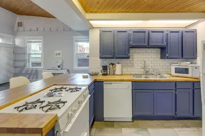a kitchen with blue cabinets and a white stove at Cozy Boho-Chic Loft about 2 Mi to Downtown Cincinnati in Cincinnati
