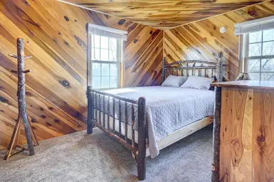 a bedroom with a bed in a wooden cabin at Racine Vacation Rental 25 Mi to Athens! in Racine