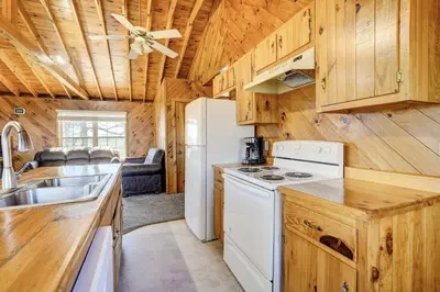 a kitchen with wooden cabinets and a white refrigerator at Racine Vacation Rental 25 Mi to Athens! in Racine