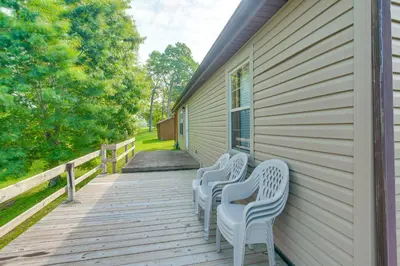four white chairs sitting on a porch of a house at Racine Vacation Rental 25 Mi to Athens! in Racine
