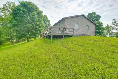a house sitting on top of a grassy hill at Racine Vacation Rental 25 Mi to Athens! in Racine