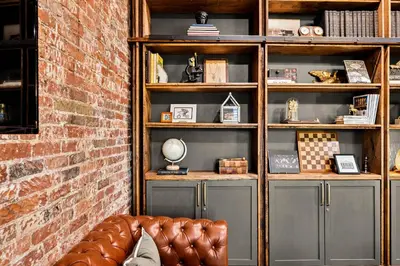 a room with a couch in front of a book shelf at The Chandler Hotel in Madison