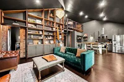 a living room with a green couch and a kitchen at The Chandler Hotel in Madison