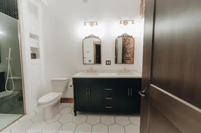 a bathroom with a sink and a toilet and two mirrors at The Chandler Hotel in Madison