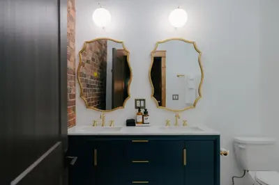 a bathroom with a sink and two mirrors at The Chandler Hotel in Madison