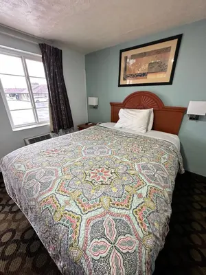 a bedroom with a large bed with a colorful quilt at Bestway Inn in Muncie