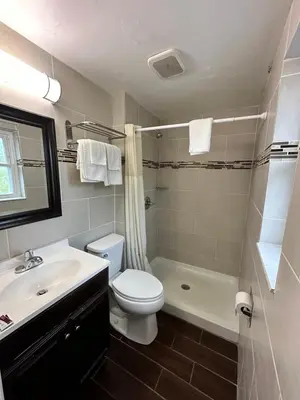 a bathroom with a toilet and a sink and a shower at Bestway Inn in Muncie