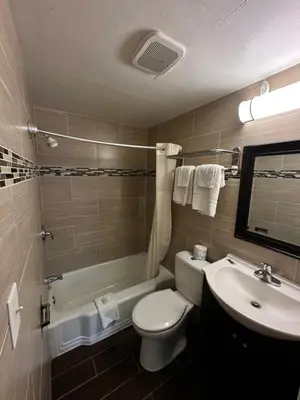 a bathroom with a white toilet and a sink at Bestway Inn in Muncie