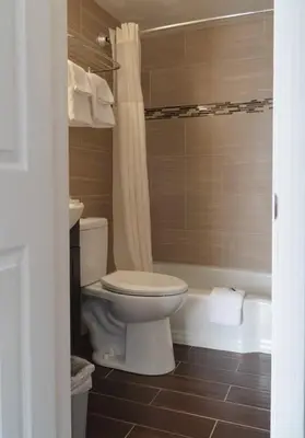 a bathroom with a toilet and a bath tub at Bestway Inn in Muncie