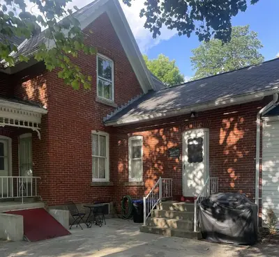 a red brick house with a front porch and stairs at Cedar Point/Kalahari/Lake Erie - Betty's Homestead in Norwalk
