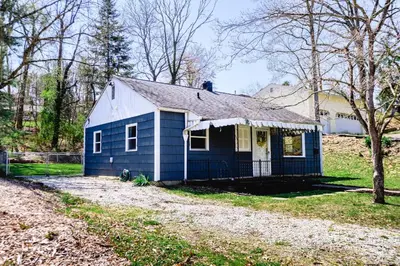 a blue house in the middle of a yard at Urban Cottage: Homey & Convenient in Huntington