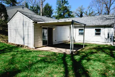 a small white house with a garage at Urban Cottage: Homey & Convenient in Huntington
