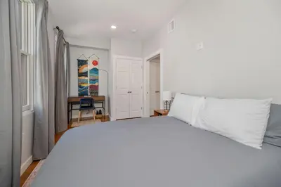 a bedroom with a white bed and a desk at Prime OTR steps to Vine St, Lux Full Bed, Workspace, fast WiFi, 50in Smart TV, Sleeps 3ppl in Cincinnati