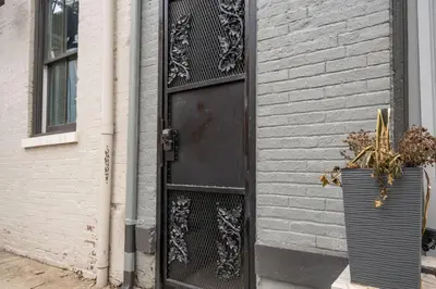 a black door on the side of a building at Prime OTR steps to Vine St, Lux Full Bed, Workspace, fast WiFi, 50in Smart TV, Sleeps 3ppl in Cincinnati