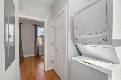 a white kitchen with a sink and a mirror at Prime OTR steps to Vine St, Lux Full Bed, Workspace, fast WiFi, 50in Smart TV, Sleeps 3ppl in Cincinnati