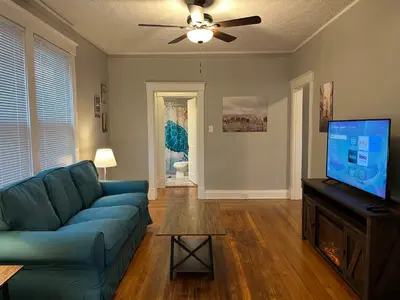 a living room with a blue couch and a flat screen tv at Rolston 1, One Bedroom Unit near Xavier Downtown in Bellevue