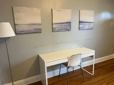 a desk with a chair and three paintings on the wall at Rolston 1, One Bedroom Unit near Xavier Downtown in Bellevue