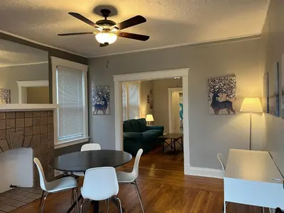 a living room with a ceiling fan and a table and chairs at Rolston 1, One Bedroom Unit near Xavier Downtown in Bellevue