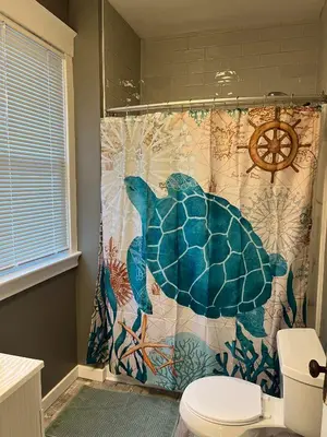 a shower curtain with a turtle on it in a bathroom at Rolston 1, One Bedroom Unit near Xavier Downtown in Bellevue