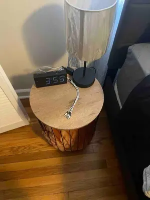 a table with a clock on it next to a bed at Cozy 3BR Condo near OSU Perfect for Students, Workers & Staycations in Columbus