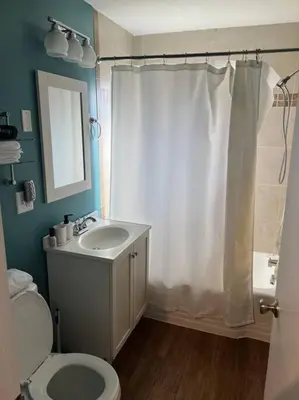 a bathroom with a white shower curtain and a toilet at Cozy 3BR Condo near OSU Perfect for Students, Workers & Staycations in Columbus