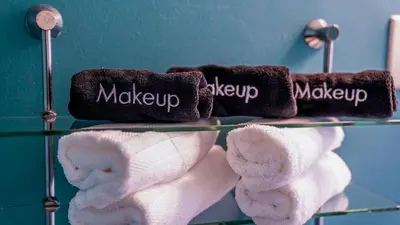 three towels on a glass shelf in a bathroom at Cozy 3BR Condo near OSU Perfect for Students, Workers & Staycations in Columbus