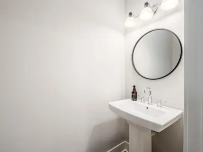 a white bathroom with a sink and a mirror at Chateau in the Village - Brand New 3BD 5BA in Columbus