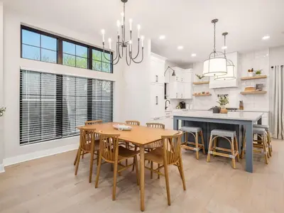 a dining room with a table and chairs and a kitchen at Chateau in the Village - Brand New 3BD 5BA in Columbus