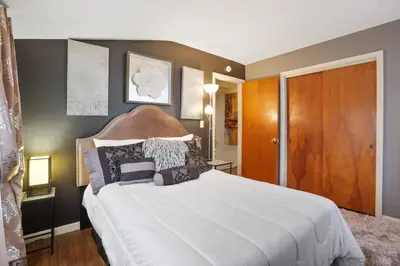 a bedroom with a large white bed with a wooden headboard at The Blue Door Dream - Stunning design Very Quiet in Columbus