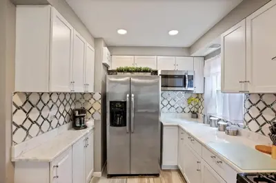 a kitchen with white cabinets and a stainless steel refrigerator at The Blue Door Dream - Stunning design Very Quiet in Columbus