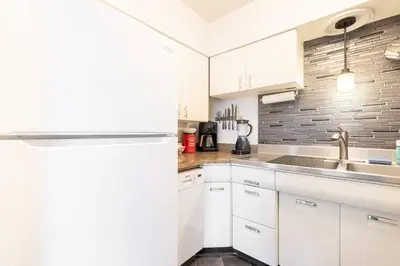 a kitchen with white cabinets and a sink at King & Queen Memory foam beds! 2-4c Georgetown Villas in Fairview Park