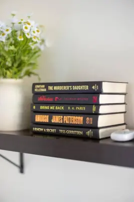 a stack of books sitting on top of a table at King & Queen Memory Foam Beds 2-2b Georgetown Villas in Fairview Park