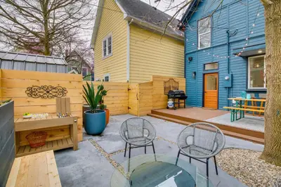 a patio with two chairs and a table and a house at Indiana Vacation Rental Walk to Madison Main St! in Madison