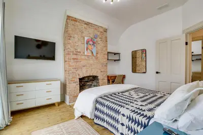 a bedroom with a bed and a brick fireplace at Indiana Vacation Rental Walk to Madison Main St! in Madison
