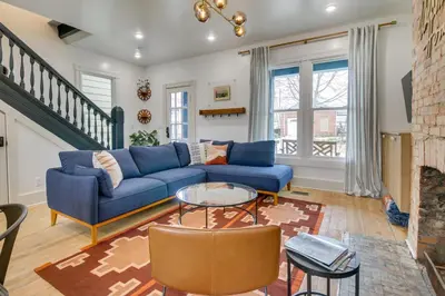 a living room with a blue couch and a fireplace at Indiana Vacation Rental Walk to Madison Main St! in Madison