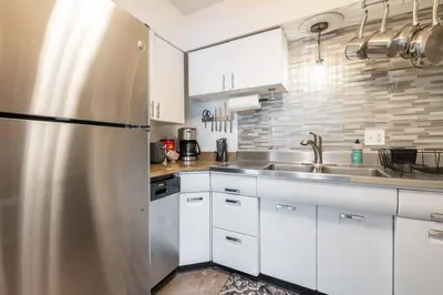 a kitchen with white cabinets and a stainless steel refrigerator at Near CLE airport and Valley 2-4a Georgetown Villas in Fairview Park