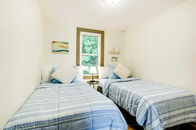two beds in a room with white walls and a window at Lakeside Indiana Vacation Rental Near Fort Wayne! in Churubusco