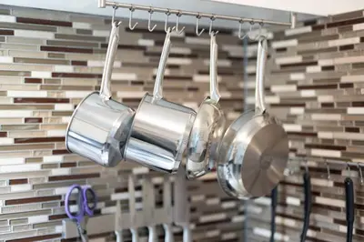 three pots hanging from a rack in a kitchen at Two Bedrooms near CLE airport 2-4b Georgetown Villas in Fairview Park