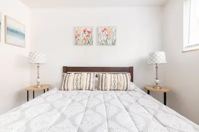 a white bedroom with a bed and two lamps at Two Bedrooms near CLE airport 2-4b Georgetown Villas in Fairview Park