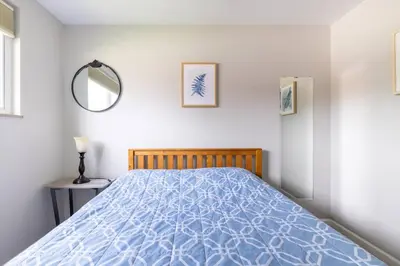 a bedroom with a bed with a blue comforter at Courtyard View near Valley 2-2a Georgetown Villas in Fairview Park