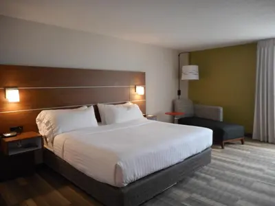 a hotel room with a large bed and a chair at Holiday Inn Express Fairfield by IHG in Fairfield