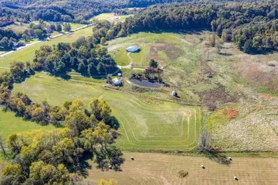 an aerial view of a large field with a house at 100 Acre Red Brick Ranch Hocking Hills Cabin Hot Tub 12 in Logan